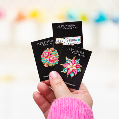 floral enamel pins with 'Alex Syberia Designs' packaging. Festive Poinsettia Wrapped with Love enamel pins