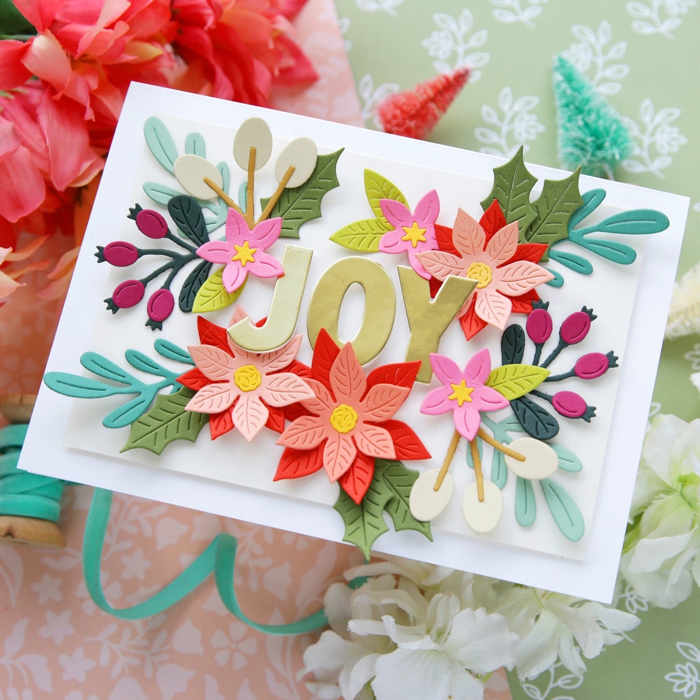 Card with floral decorations spelling 'JOY' on a floral background alex syberia designs die